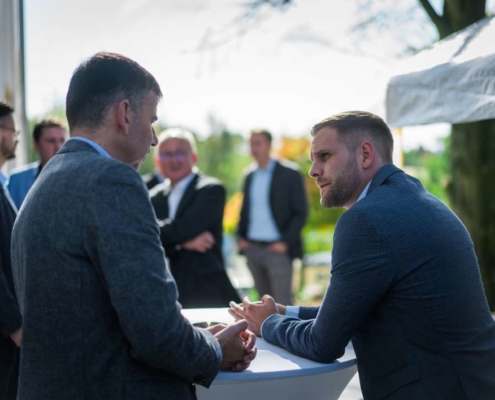 zwei männer im gespräch an hochtisch