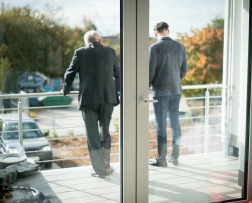 zwei männer schauen vom balkon