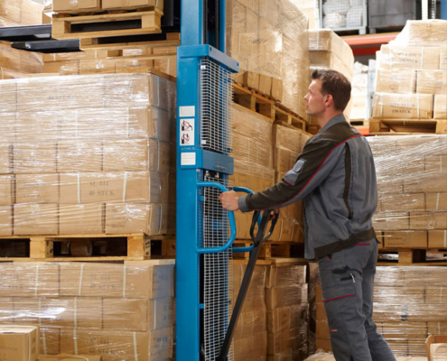 warehouse staff operating high-lift trucks with pallets and packages