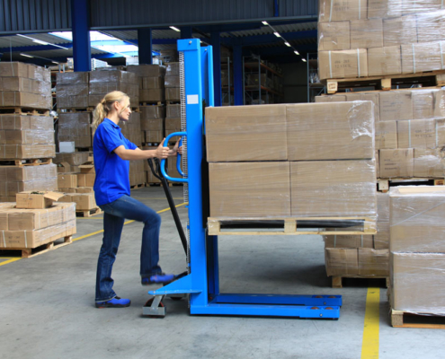 warehouse staff operating high-lift trucks with pallets and packages