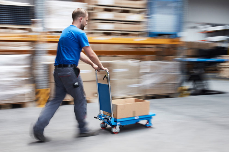 man moves blue lift table into stock