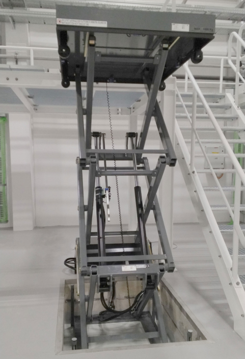 Ausgefahrener Scherenhubtisch mit sichtbarer Hydraulik in bauseitiger Grube Mehrfach-Scherenhubtisch in ausgefahrener Position mit sichtbarem Hydrauliksystem in einer vorhandenen Grube. Industrieumgebung mit Podestzugang.